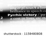 Small photo of pyrrhic victory word in a dictionary. pyrrhic victory concept.