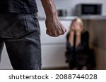 Small photo of alcoholic husband beats wife with fist. Woman covers herself with hands. Violence in family. cropped man attacks woman, domestic violence. Drunk husband beats wife. An aggressive man hits lady