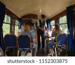 Small photo of 15th July 2018- The bar in a vintage carriage on a steam train, with passengers having their fares checked by the ticket collector, at the Gwili Railway, Bronwydd Arms, Carmarthenshire, Wales, UK.
