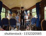 Small photo of 15th July 2018- The ticket collector checking passengers fares in the bar on a vintage steam train at the Gwili Railway, Bronwydd Arms, Carmarthenshire, Wales, UK.