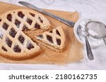 Slice of pie called 'Linzer Torte', a traditional Austrian shortcake pastry topped with fruit preserves and nuts with lattice design