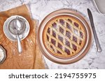 Top view of pie called 'Linzer Torte', a traditional Austrian shortcake pastry topped with fruit preserves and nuts with lattice design