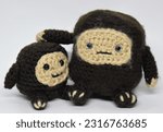 Small photo of Hand Made Amigurumi Sasquatch and Child Bigfoot with Baby Isolated Against White Background Crocheted Yarn Art Stuffed Toy