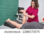 Small photo of Physiotherapist using manual techniques to treat a foot injury in a patient. The therapist applies pressure and massages the affected area to help improve range of motion and alleviate pain