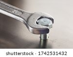 Wrench tightens  bolt in steel...
