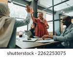 Small photo of Two successful businesswomen high fiving each other during an office meeting. Cheerful businesswomen celebrating their achievement. Happy businesspeople working as a team in a multicultural workplace.