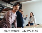 Professional man having a meeting with his team in an office. Group of business people brainstorming in an office. Creative professionals working on a project in a startup.