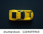 Metal toy sports car of yellow color. View from the top