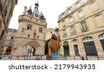 Tourism in Bordeaux, France. Traveler girl walking in Bordeaux discovering Porte Cailhau a medieval gatehouse of the old city walls.