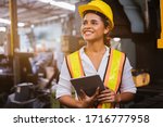 Small photo of Industry maintenance engineer woman dark skin wearing uniform and safety helmet under inspection and checking production process on factory station by tablet. Industry, Engineer, construction concept.
