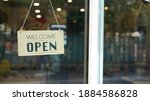 Small photo of Open and closed flip sign in front of coffee shop and restaurant glass door. Wooden sign of place's status. Say sorry we're closed. Please come back again and another side is Welcome we're open