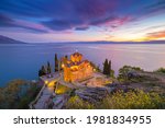 Historic Church of Saint John the Theologian, situated on the cliff over Kaneo Beach overlooking Lake Ohrid with magnificent twilight sunset, Republic of North Macedonia.