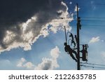 Small photo of The silhouette of power lineman replacing a transformer and hotline clamp, bail clamp. Using clamp stick grip all type, wearing personal protective equipmen