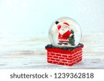 Santa Claus in glass ball on wooden table background. symbol of new year and Christmas holidays. festive winter season. template for design. copy space