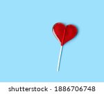 red Lollipop heart on abstract blue background. heart shape candy on stick, romantic sweet gift. symbol of love. Valentine's day, 14 february concept. flat lay. copy space. element for design.