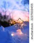 Small photo of burning sparkler in snow, winter nature abstract background. Christmas and new year holidays. festive winter season. dreams, fantasy, romantic atmosphere image. Hello or goodbye winter concept