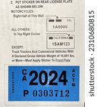 Small photo of LOS ANGELES, Nov 19th, 2022: DMV Department of Motor Vehicles California registration sticker tag 2024 attached to its renewal notice close up.