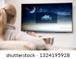 Woman watches tv with 8k ultra hd resolution. Picture on the screen created in graphic software.