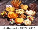 Salty snacks. Pretzels, chips, crackers in wooden bowls. Unhealthy products. food bad for figure, skin, heart and teeth. Assortment of fast carbohydrates food. 