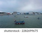 Small photo of Boats lie at anchor in Margate Harbour at high tide, with the Margate skyline in the background.