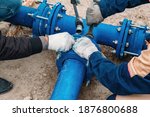 Workers installing water supply pipeline system, close up