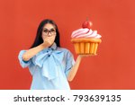 Funny Girl Holding Big Huge Giant Sweet Muffin Cupcake. Woman with a sweet tooth considering to eat huge patty cake
