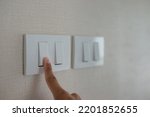 Small photo of He was using his finger to turn off the unused lights in the house to save electricity home expenses, save energy and help reduce global warming.