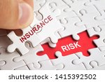 Hand holding piece of puzzle with word INSURANCE RISK. Business concept