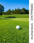 Small photo of View of Golf Course with Golf Ball. Golf course with a rich green turf beautiful scenery.
