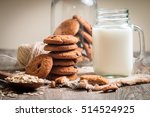 Chocolate chip cookies with milk on burlap and rustic wooden table