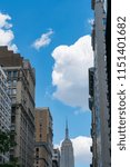 Small photo of Clouds move over the Empire State Building at Fifth Avenue Midtown Manhattan New York USA on June 26 2017.