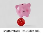 Piggy bank standing balanced on red dice - Concept of economy and financial risk