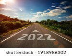 2022 written on highway road with arrow in the middle of empty asphalt road and beautiful blue sky. Concept for vision 2021-2022.