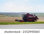 Small photo of Nizhny Novgorod, Russia - July 17, 2021: Wheat harvest season, cropper harvester harvesting wheat from the field. Sunny summer day in the village, agricultural work on the farm
