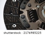 Small photo of Close-up of the clutch disc of a car with a manual transmission, on a gray background, selective focus. Car clutch repair kit. Automotive parts.