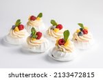 Mini Pavlova Cake meringue dessert with fresh raspberries, blueberries and mint. and soft inside.Summer dessert. French cake. 