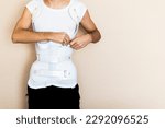 Small photo of Teenage boy putting on a Boston Orthopedic corset to correct the scoliosis of his spine.