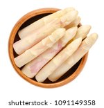 Small photo of Raw white asparagus tips in wooden bowl. Blanched sparrow grass shoots. Cultivated Asparagus officinalis. Vegetable with thick stems and closed buds. Macro food photo close up from above over white.