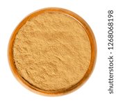 Small photo of Cinnamon powder in wooden bowl. Spice from inner bark of the Ceylon cinnamon tree, Cinnamomum verum. Brown aromatic condiment and flavoring additive. Macro food photo closeup from above over white.