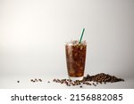 Iced americano coffee with coffee beans on grey background, Glass of black coffee, Beverage at coffee shop.
