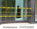 Small photo of Broken glass window on retail store front from criminals looting and rioting in Manhattan New York during racial protests