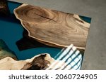 Small photo of Expensive vintage furniture. The table is covered with epoxy resin and varnished. Luxury quality wood processing. Reflections of light in polished varnish. A nautical epoxy river in a rectangular slab