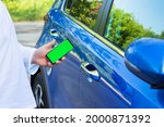 Man uses mobile application on smart phone to lock or unlock car door. Concept of vehicle keyless security