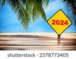 New year 2024 written on yellow sign on plank and beach background. Happy holiday concept and natural relaxation work life balance idea