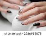 Manicure with gel polish. Female nails with pink and black colours.
