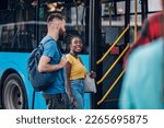 Diverse group of friends waiting for a bus while at a bus stop. Riding, sightseeing, traveling to work, city tour, togetherness. Copy space. Focus on an african american woman.
