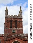 Small photo of Bell tower of Crediton Parish Church of the Holy Cross and the Mother of Him Who Hung thereon in spring sunny day, Devon, UK, March 4, 2017