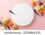 Small photo of Modern Halloween arrangement. Overhead capture of thematic items: small golden pumpkins, ghastly spiders, spiderweb, bats, and confetti on pastel pink base. Empty circle perfect for messages or ads
