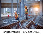 Engineer railway under inspection and checking construction railway switch and checking work on railroad station by laptop.Engineer wearing safety uniform and safety helmet in work.