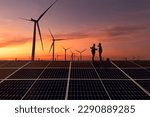Silhouette engineer working on solar cell plant with windmill field .Solar cell smart grid and windmill are ecology energy renewable sunlight alternative green power environment factory concep.t